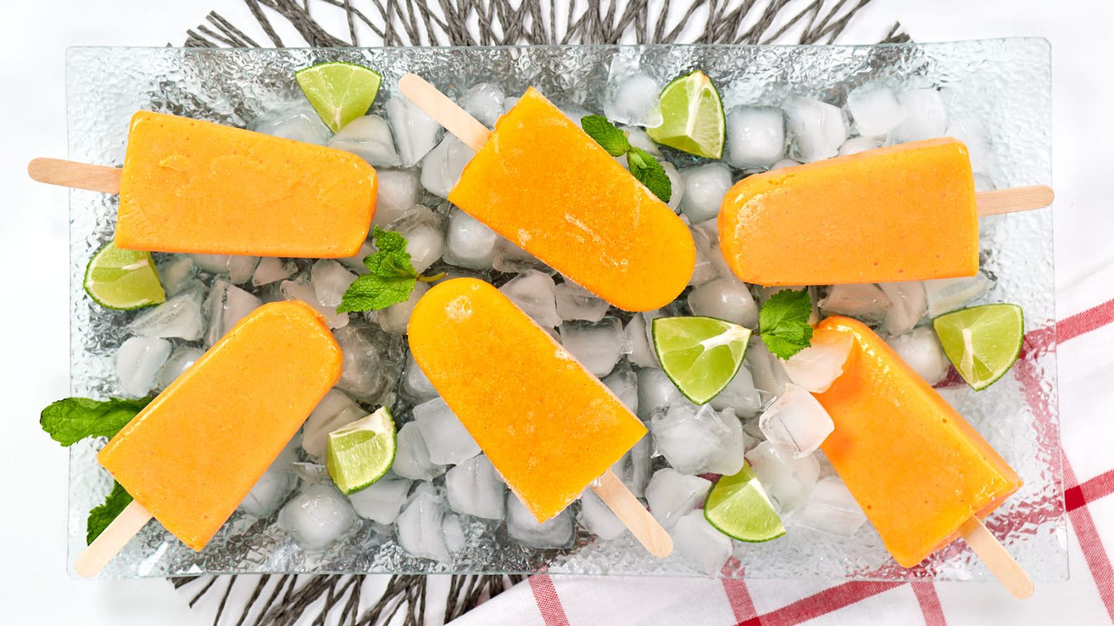 Mango popsicles with sliced limes.