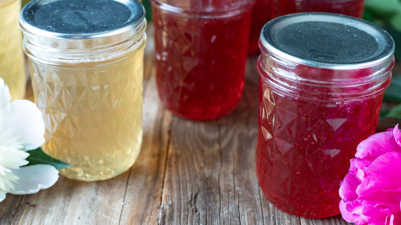 Jars of pink and pale yellow jelly.