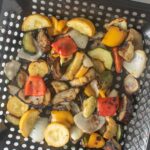 Smoked vegetables in a grill basket.