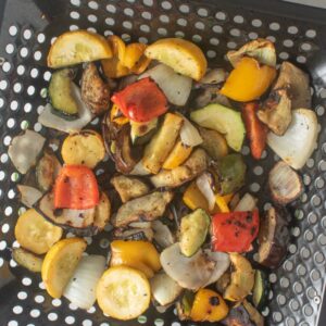 Smoked vegetables in a grill basket.