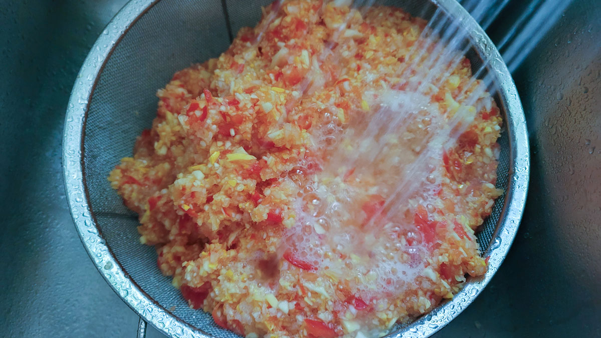 Rinsing the salt off of the vegetables in a colander.
