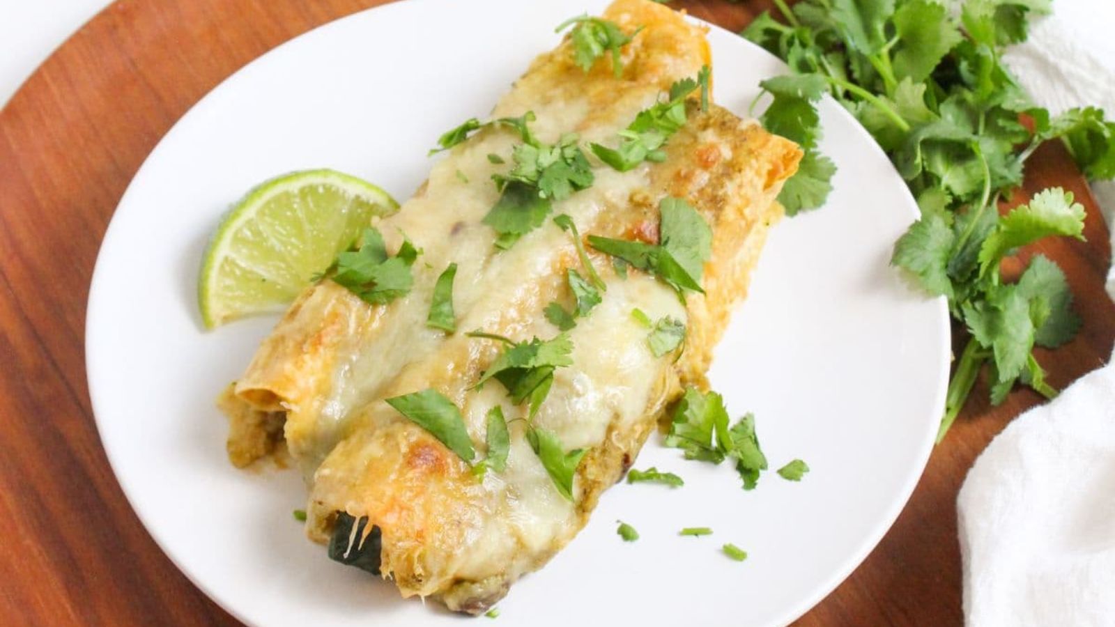 Two chicken enchiladas on a plate.