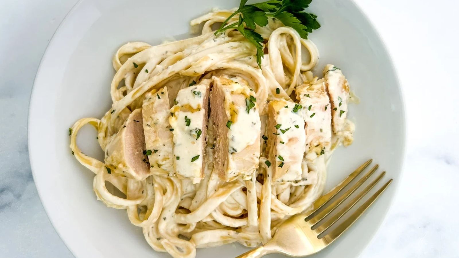Pasta with sliced chicken on top.
