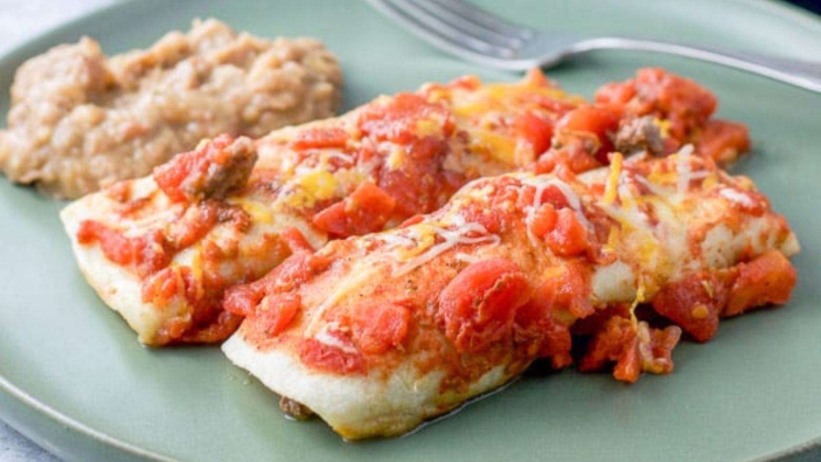 Two ground beef enchiladas on a plate.