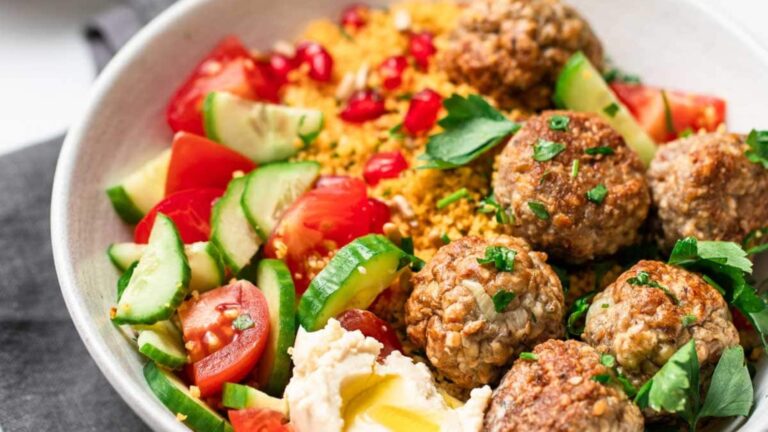 Meatballs with sliced cucumber and tomatoes.