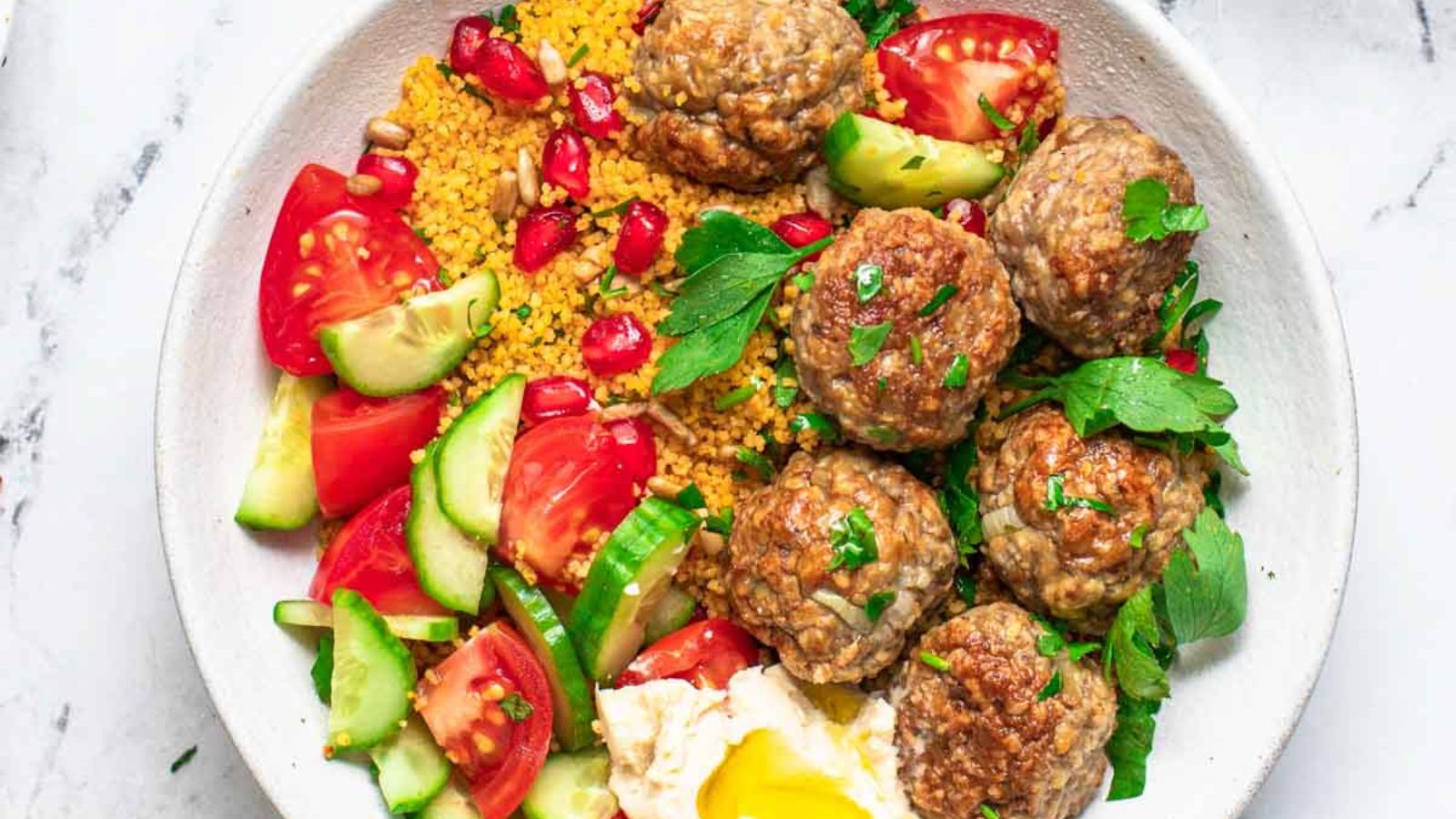 Meatballs with sliced cucumber and tomatoes.