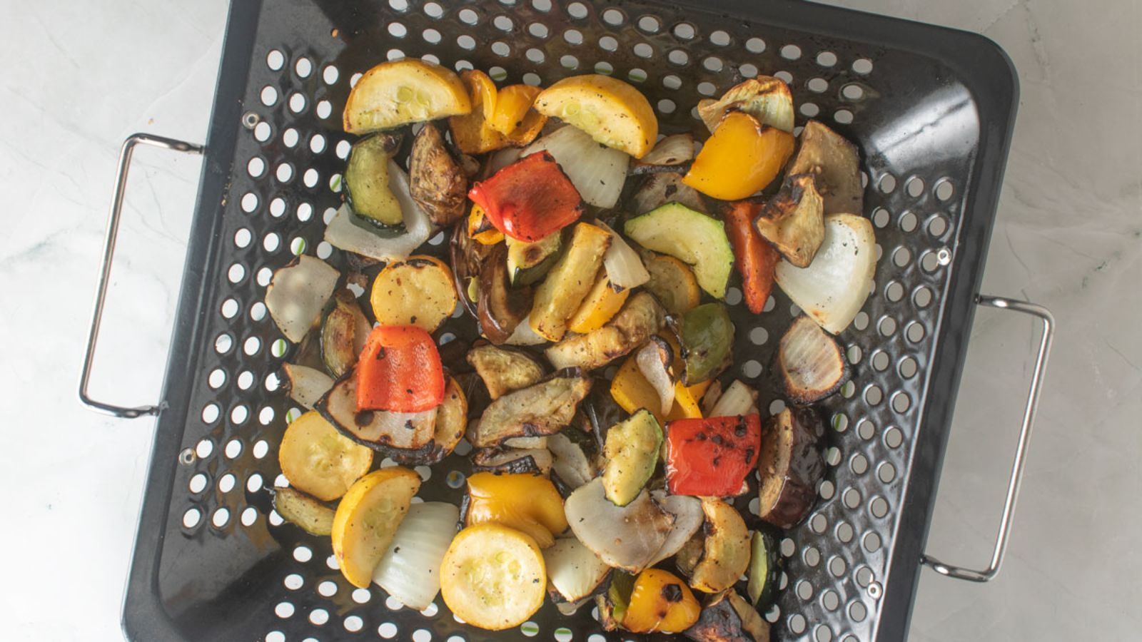 Smoked vegetables in a grill basket.