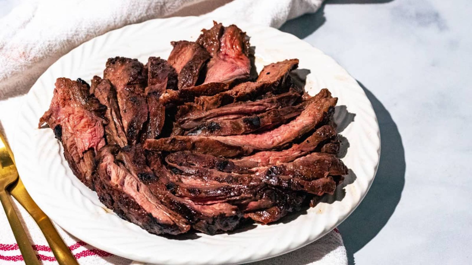 Sliced skirt steak on a plate.