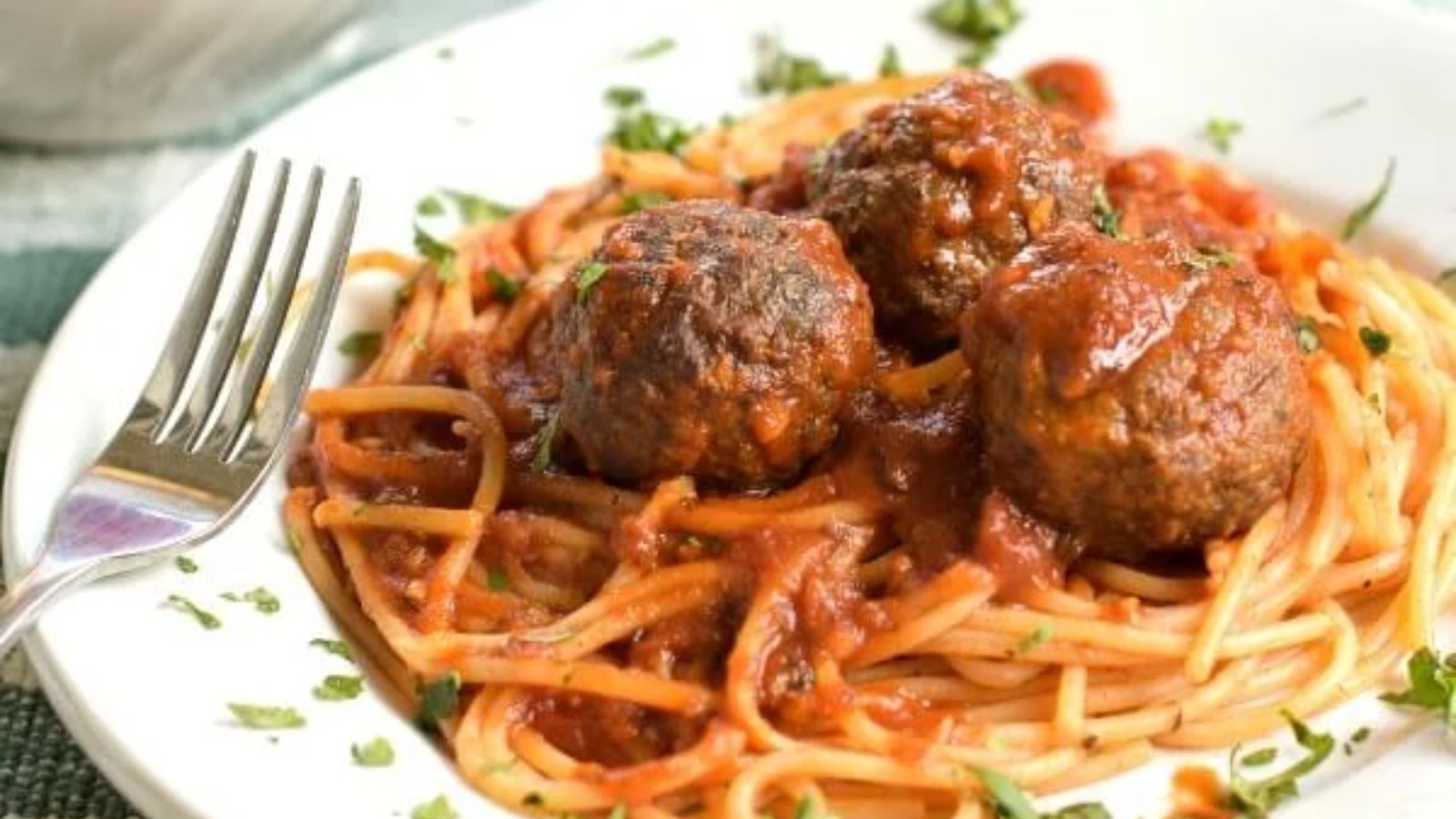 Pasta with meatballs on top.