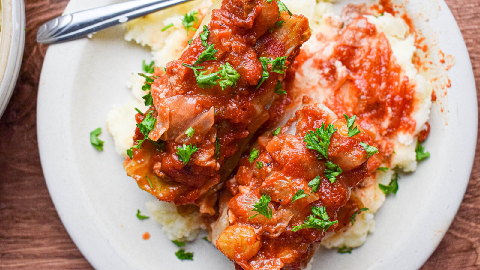 Two cabbage rolls with sauce.