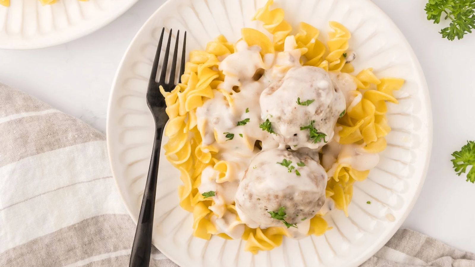 Pasta with meatballs and sauce on top.