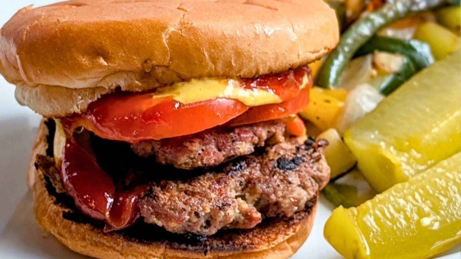 Beef brisket burger with sliced tomatoes.