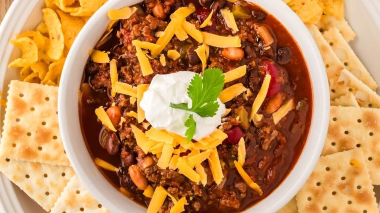 Venison chili in a bowl with biscuits.