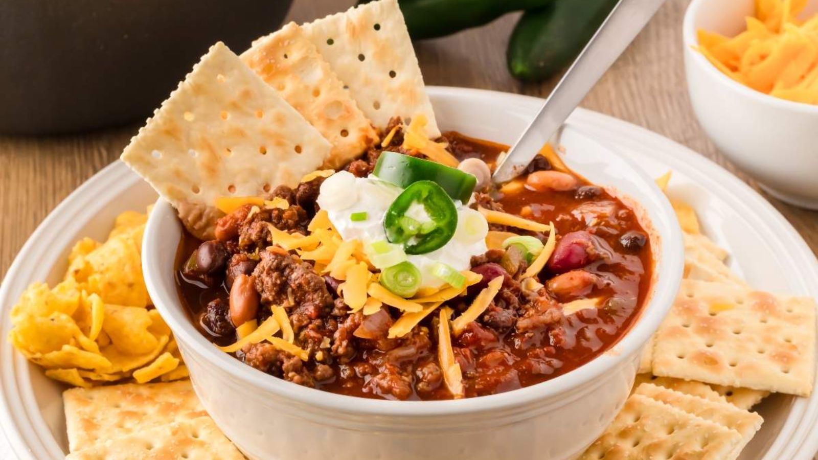 Venison chili in a bowl with biscuits.