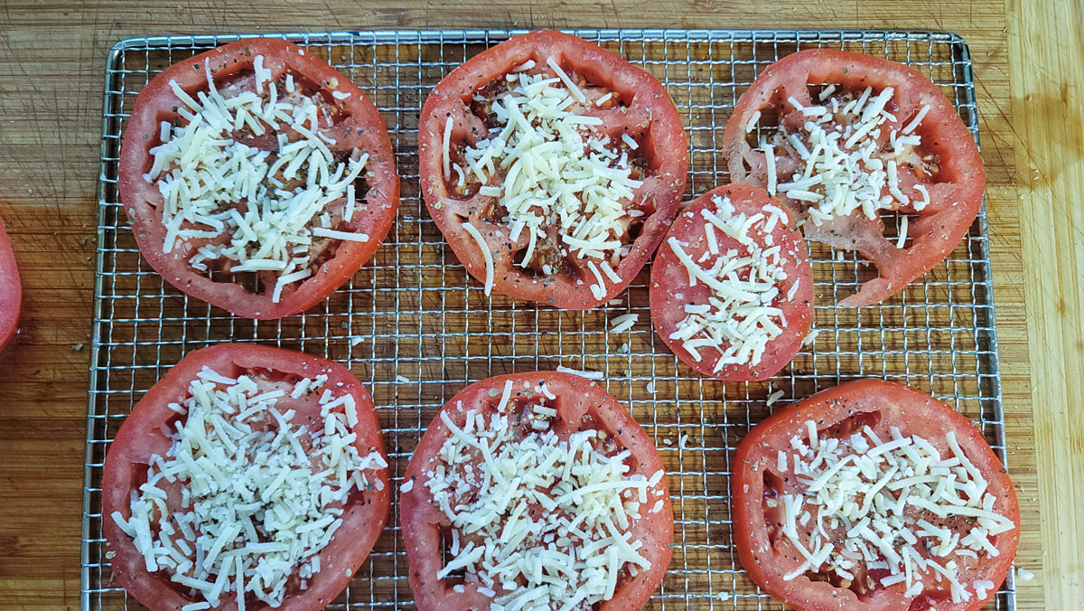 Each tomato slice sprinkled with parmesan cheese.