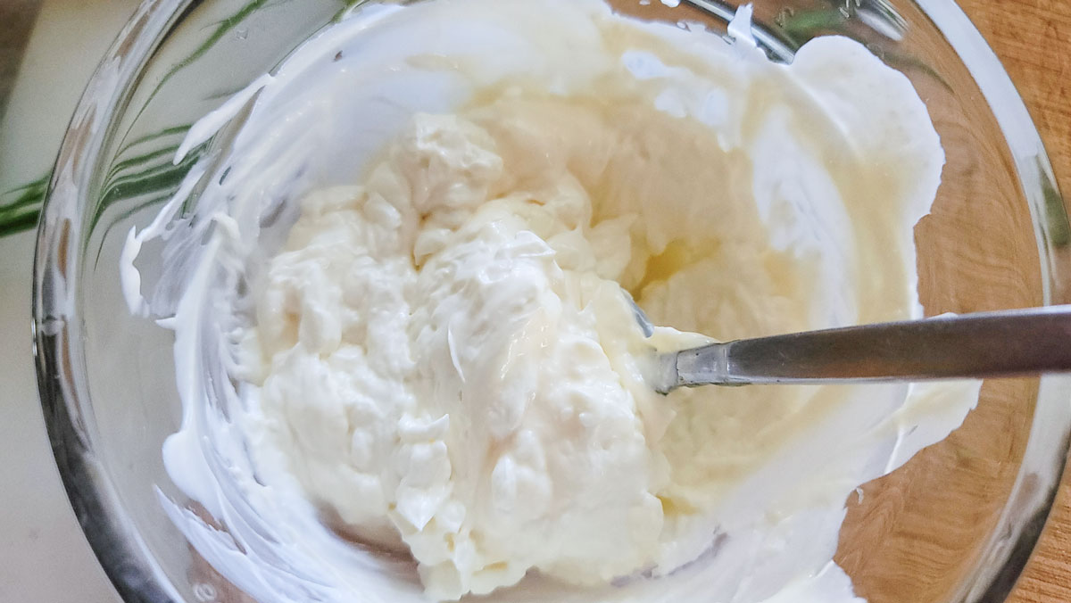 Cream cheese mixed with mayonnaise in a small bowl.