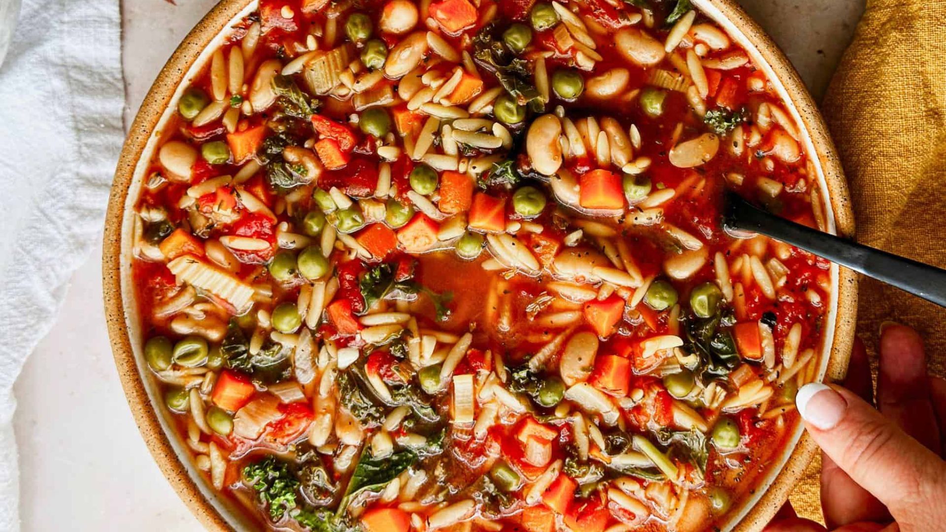 Colorful bowl of soup in a brown bowl.