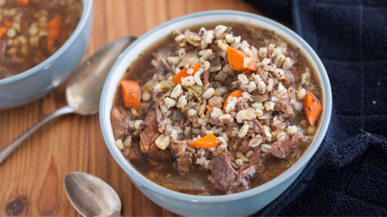 Two bowls of venison soup in grey bowls