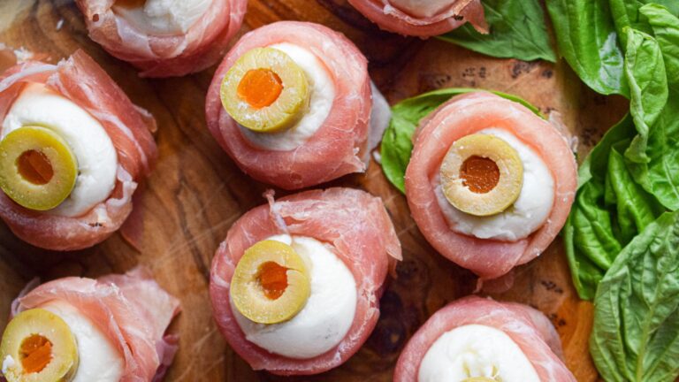 Antipasto eyeballs on a wooden board.