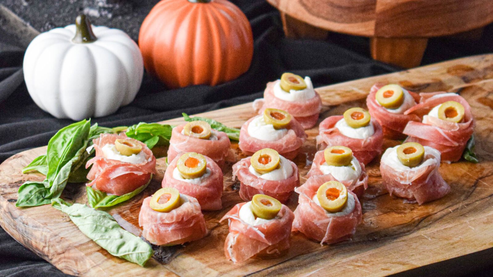 Antipasto eyeballs on a wooden board.