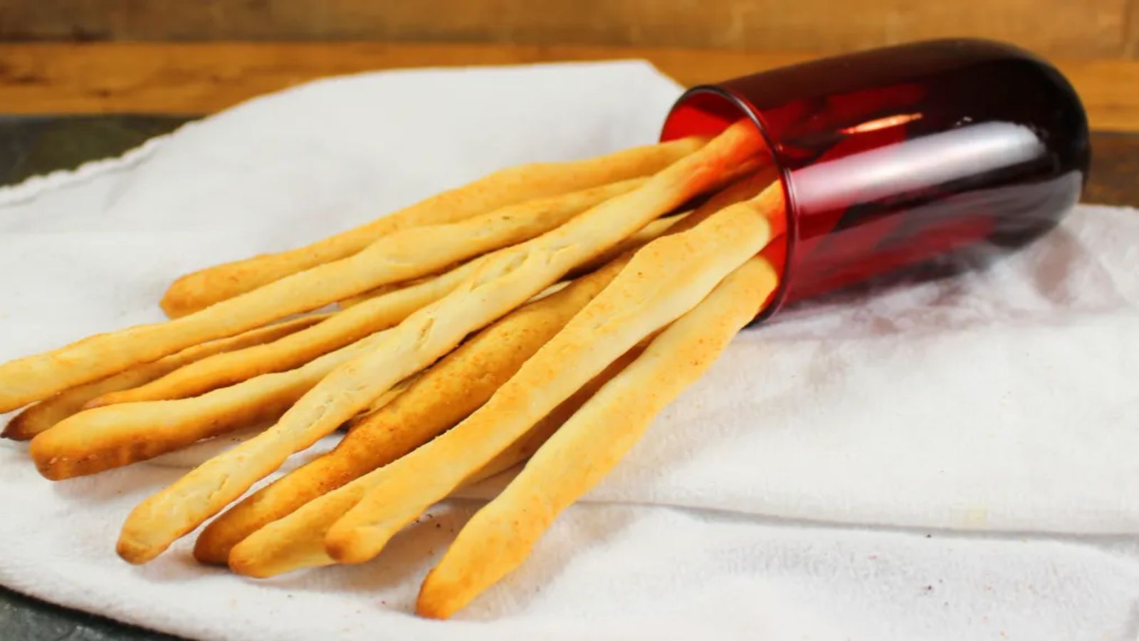 Biscuit breadsticks on top of a white cloth.
