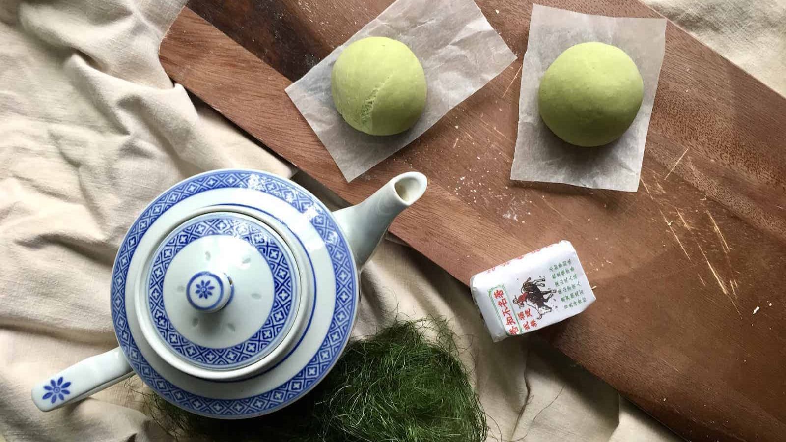 Matcha buns on a wooden board.