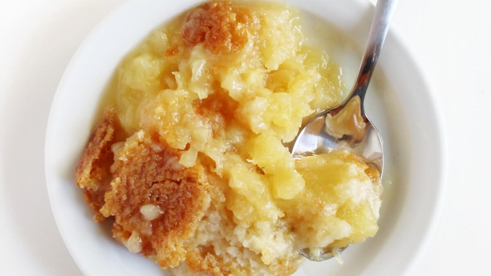 Pineapple dump cake in a bowl.
