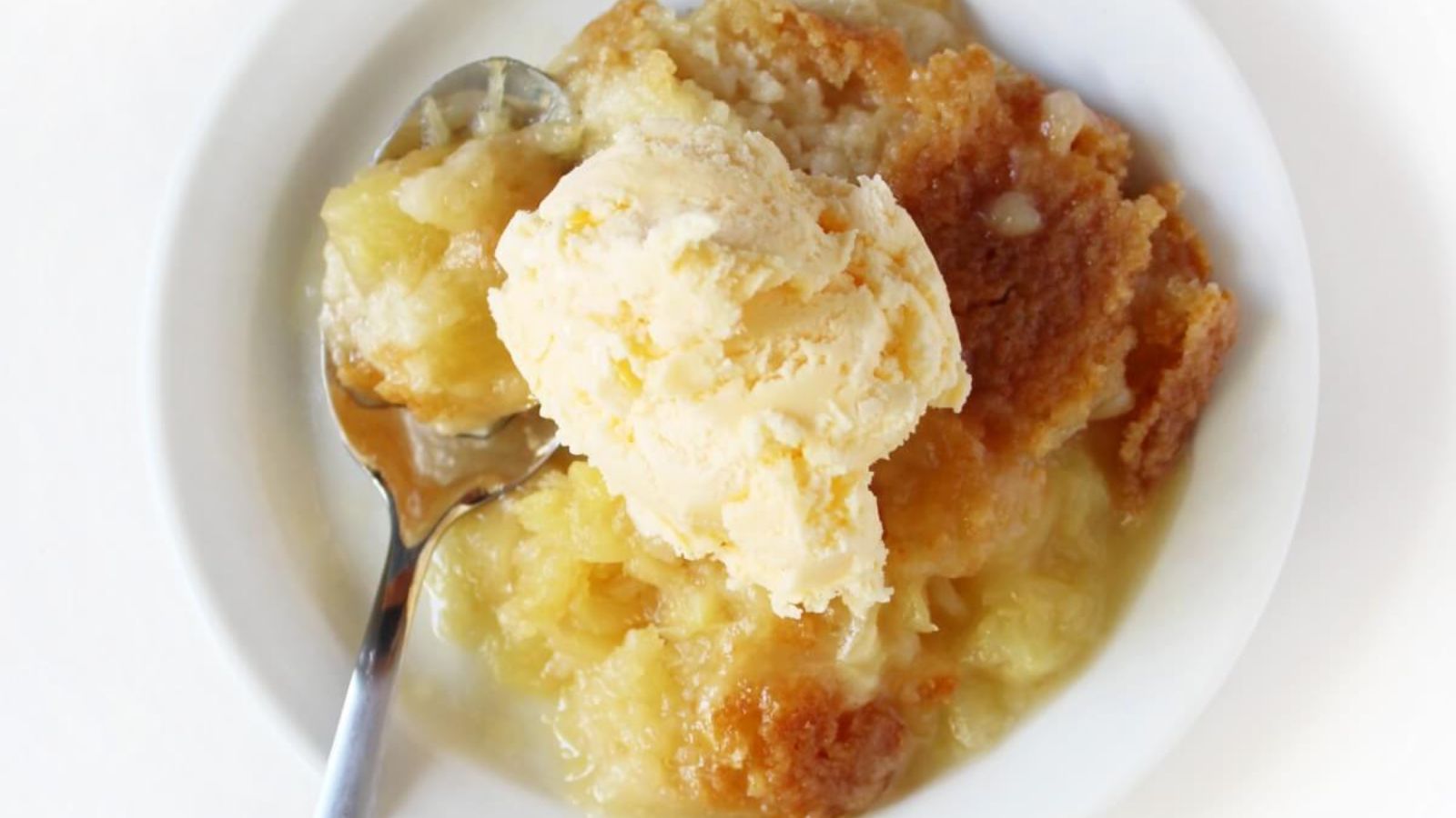 Pineapple dump cake with a scoop of ice cream.