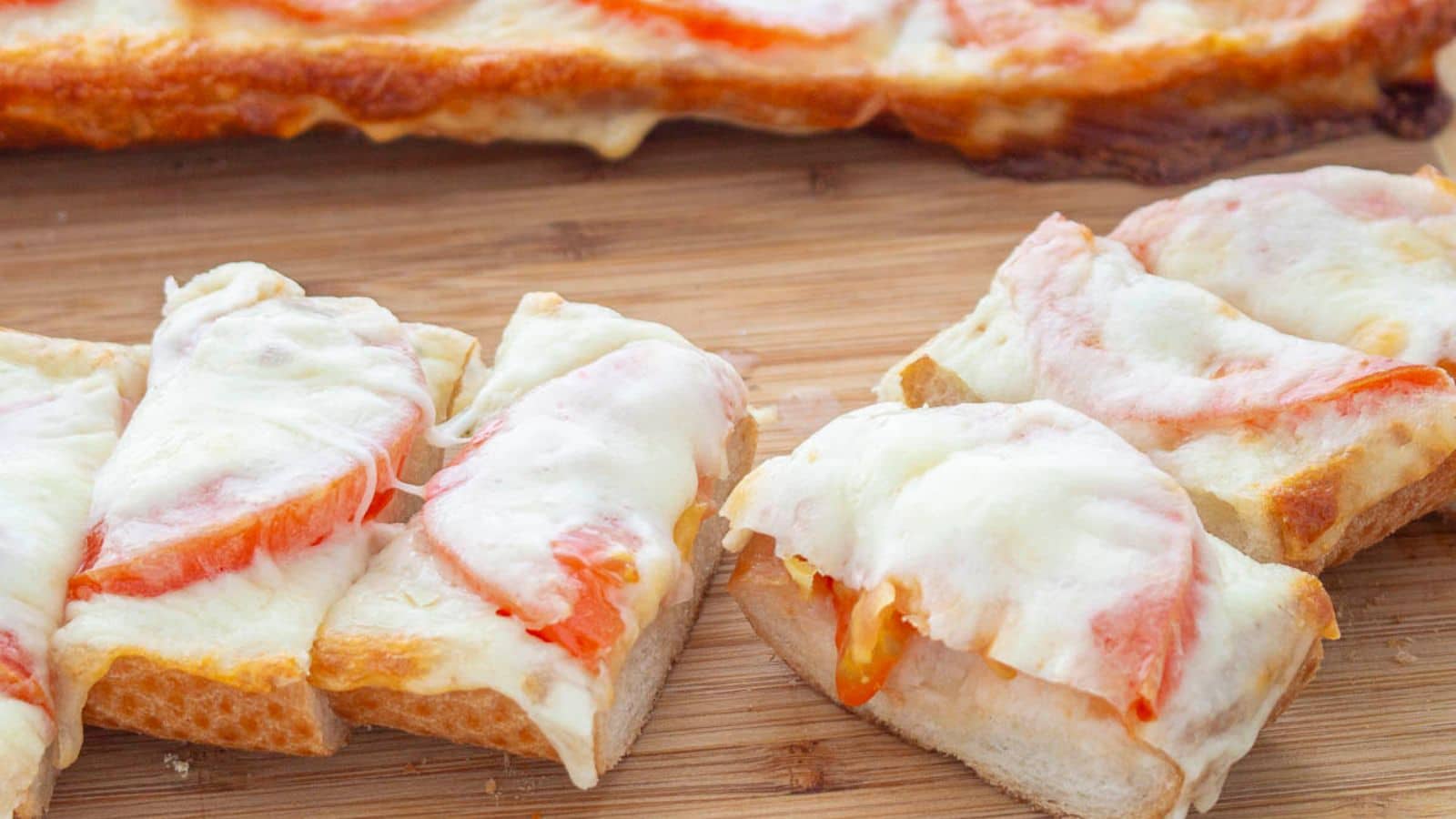 Mozzarella melted on top of tomatoes on Italian bread.