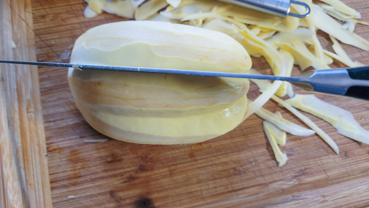 Chef's knife inserted into one of the "low valleys" of the ribbed squash.
