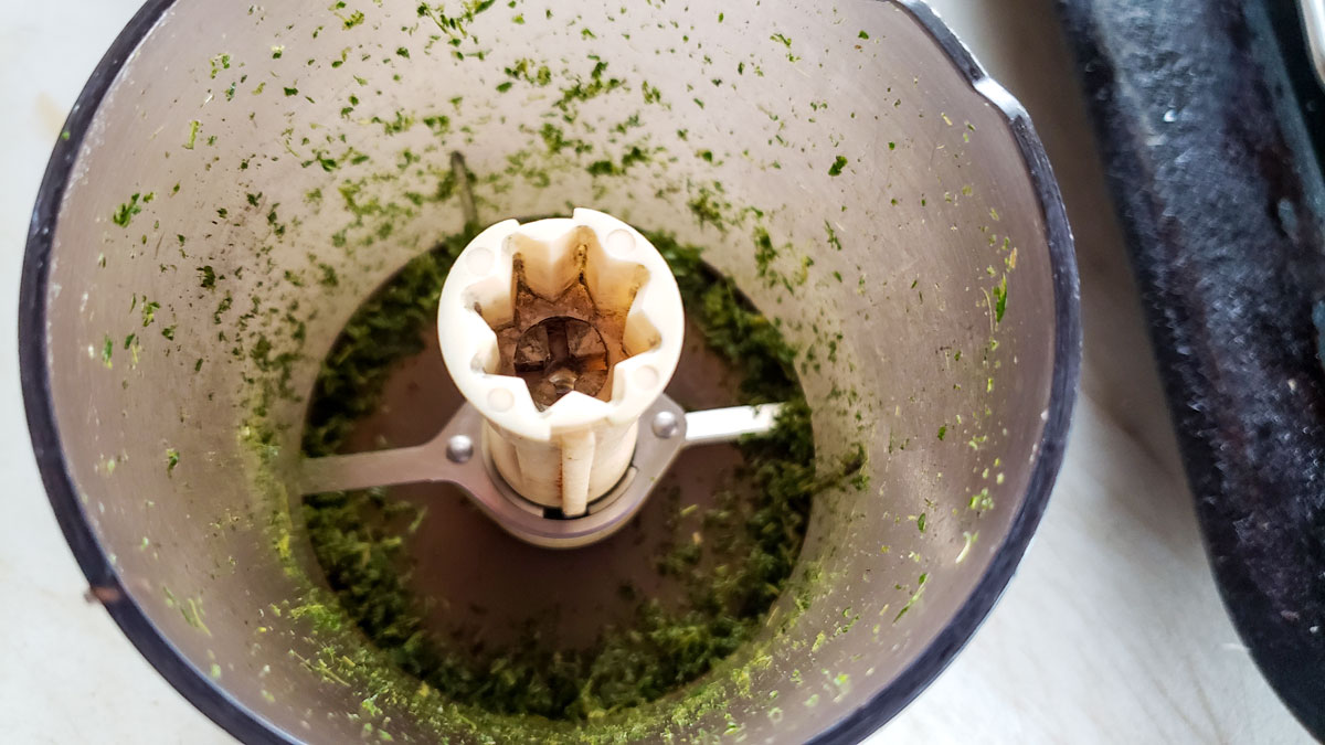 Chopped herbs in the food processor bowl.