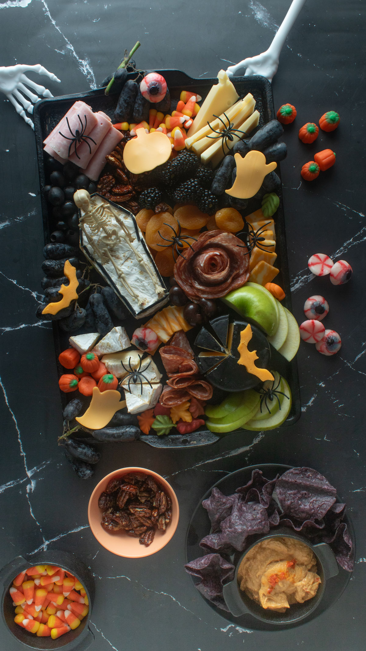 Spooky Halloween charcuterie board with a skeleton in a coffin made of brie.
