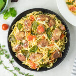 Large bowl of pasta with tomatoes, chorizo and basil.