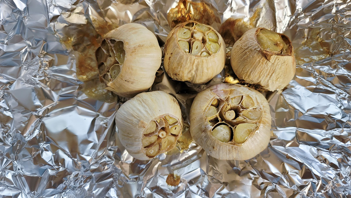 Roasted garlic on a piece of aluminum foil.