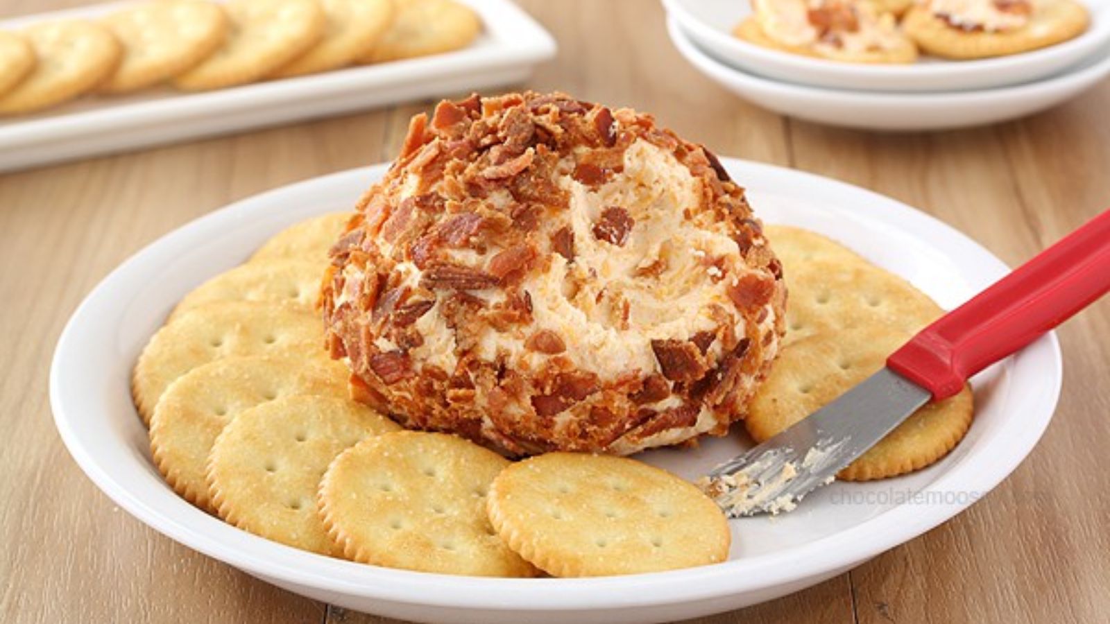 Cheddar cheese ball wrapped in bacon bits.
