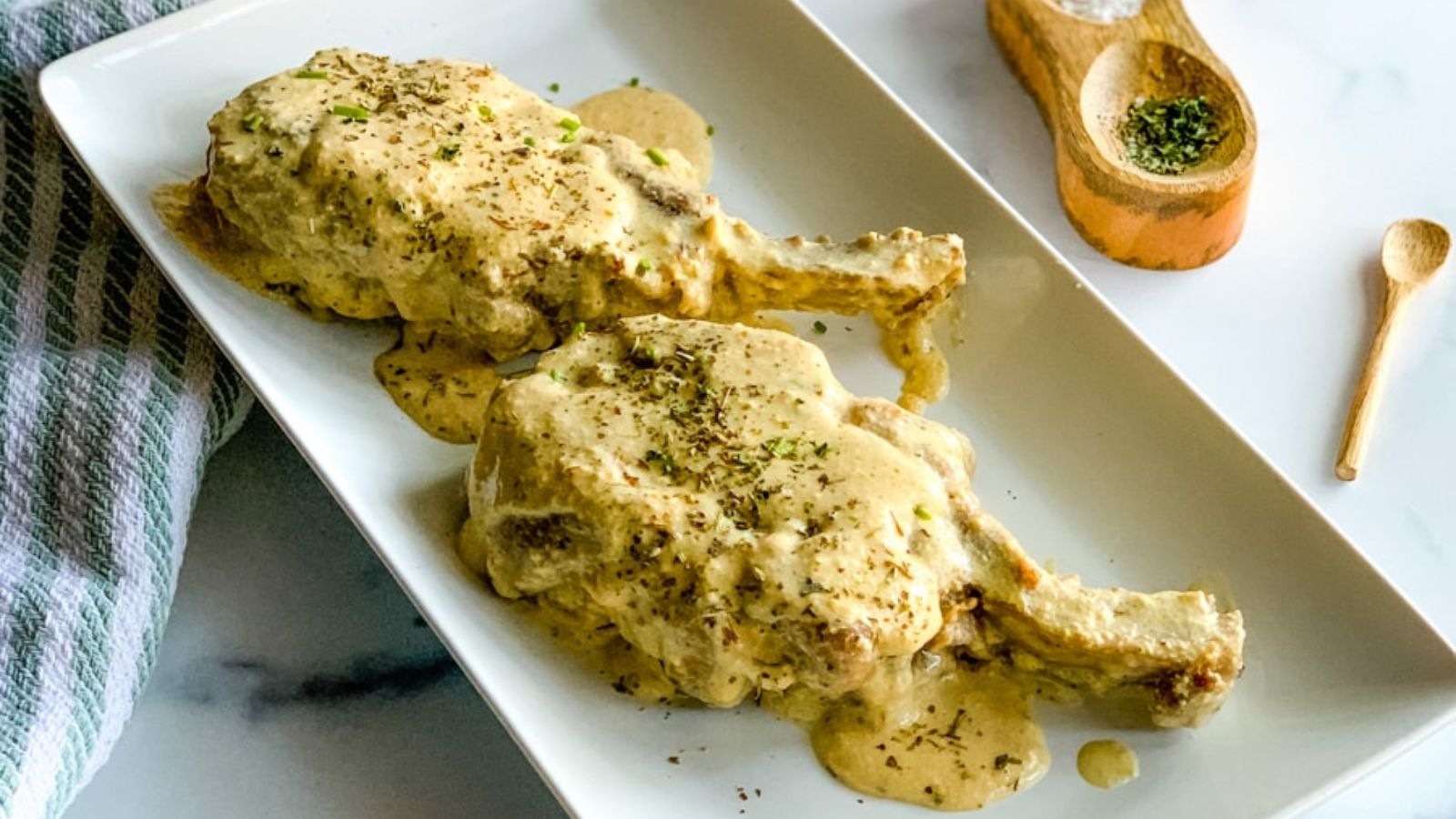 Pork chop with ranch on a plate.