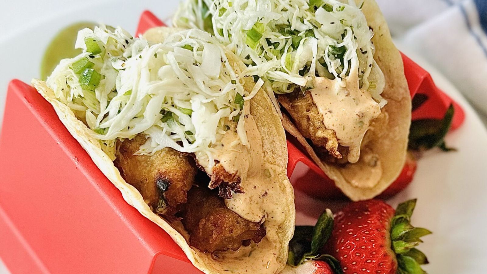 Two tacos with fried fish.