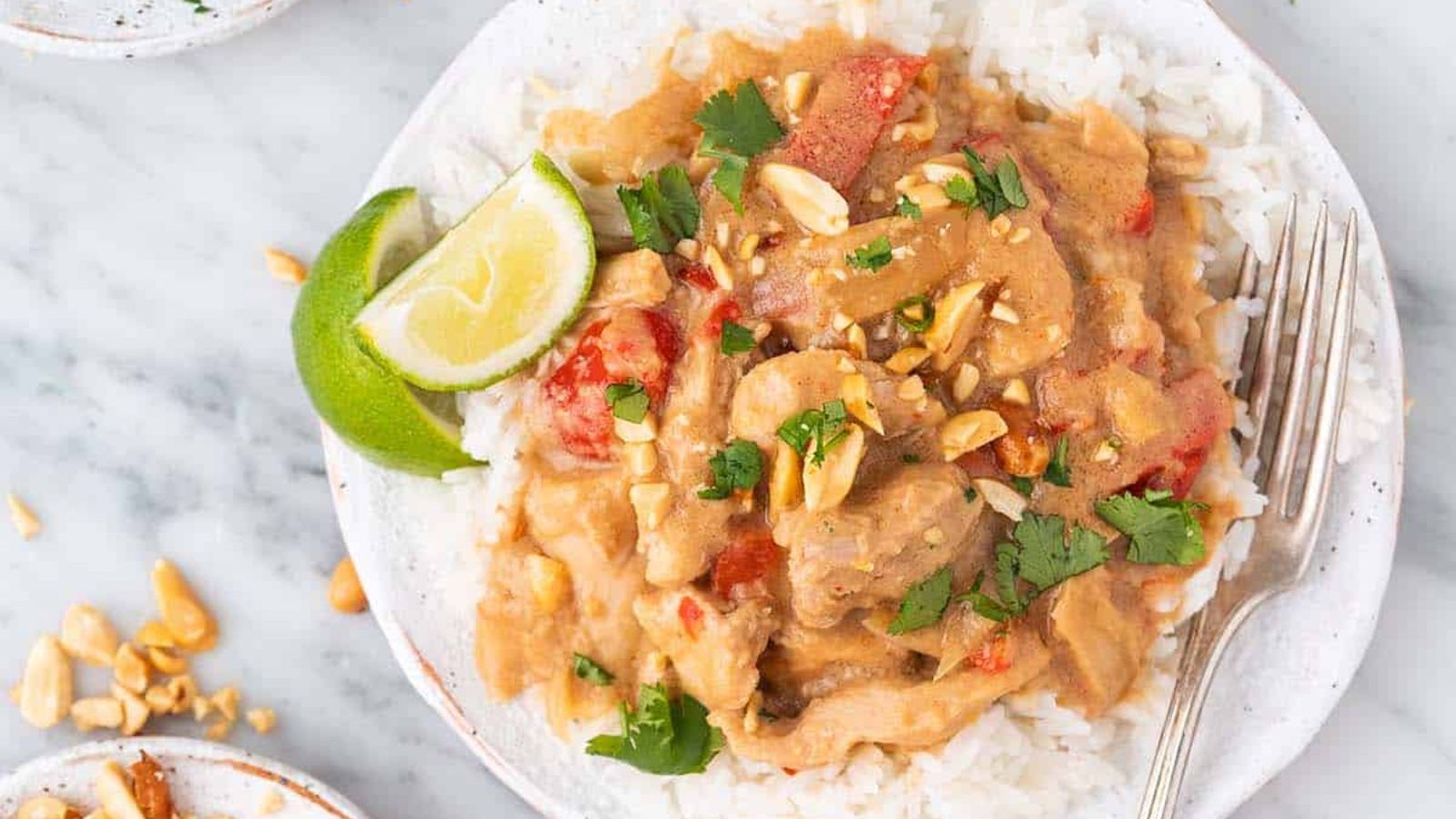 Peanut chicken with sliced lime on the side.