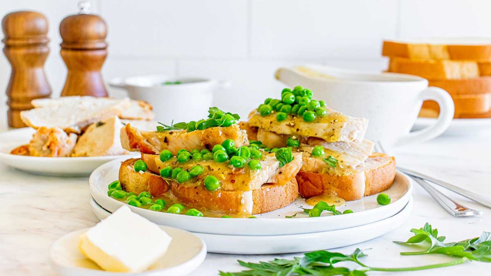 Turkey sandwich with green peas on top.