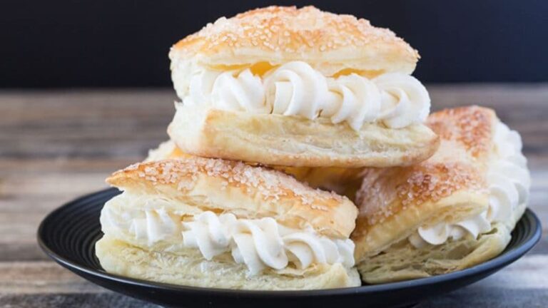 Cream filled pastries on a white board.