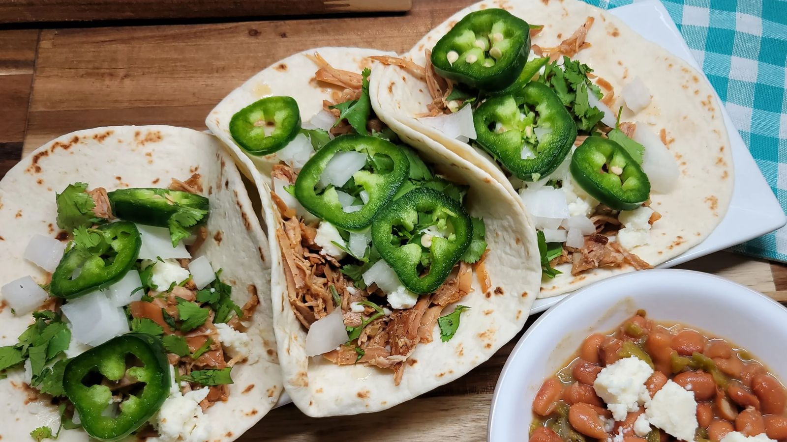 Three pork tacos with green peppers.