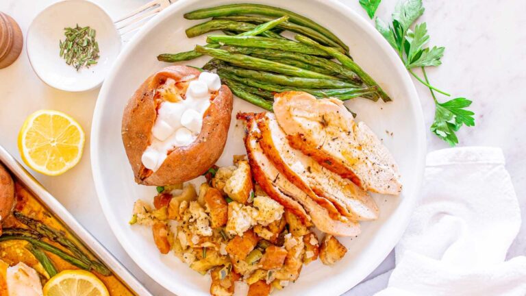 Sliced turkey breast with veggies on the side.