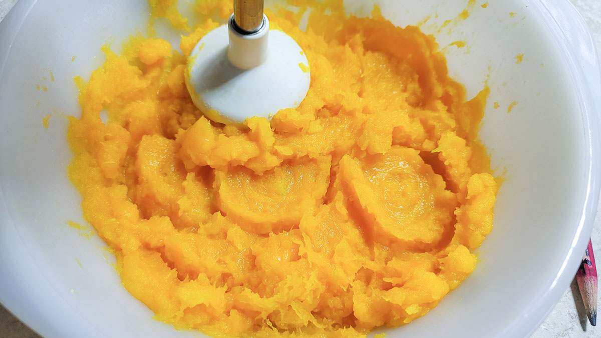 Mashing the squash in a bowl.