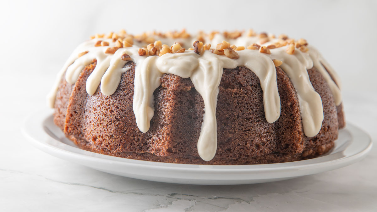 Butternut squash cake with cream cheese glaze drizzled down the sides.