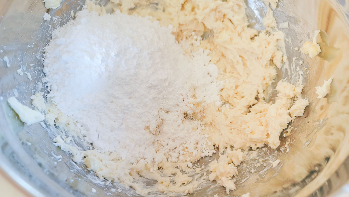 Powdered sugar added to the bowl with the cream cheese mixture.