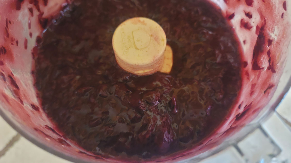 Grape skins processed in a food processor bowl.