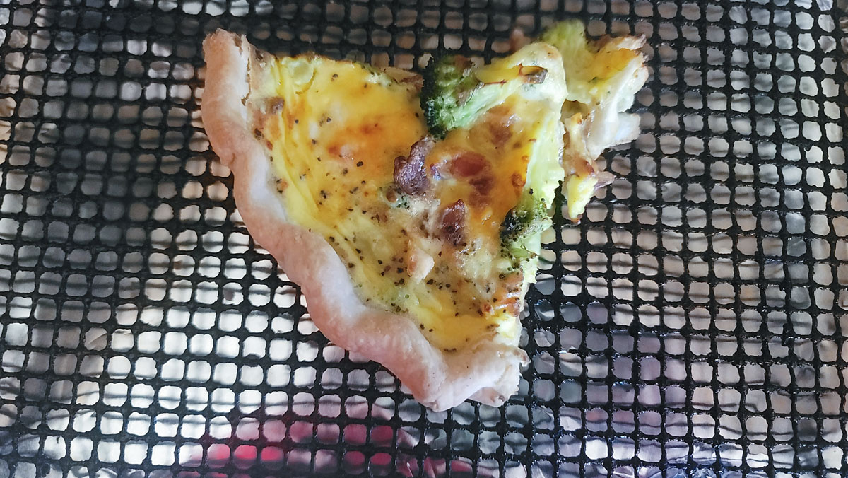 Piece of quiche with caramelized edges.