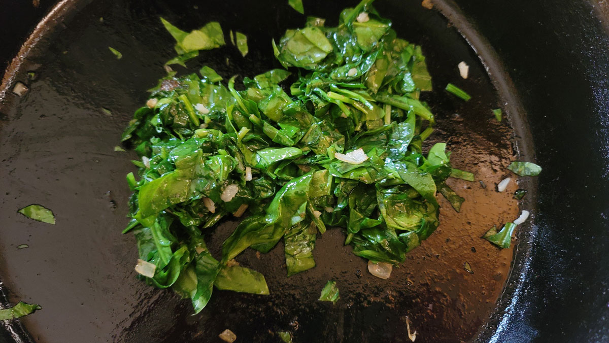 Wilted spinach in cast skillet.