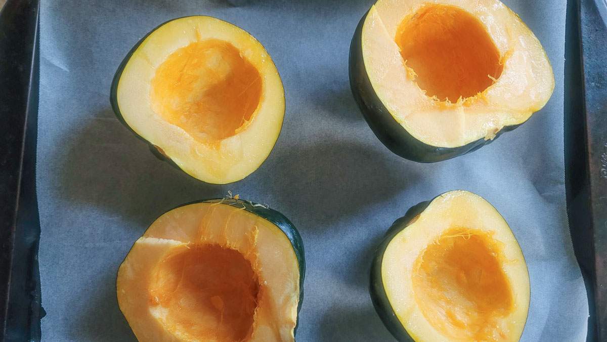 Squash on a baking sheet with the seeds removed.