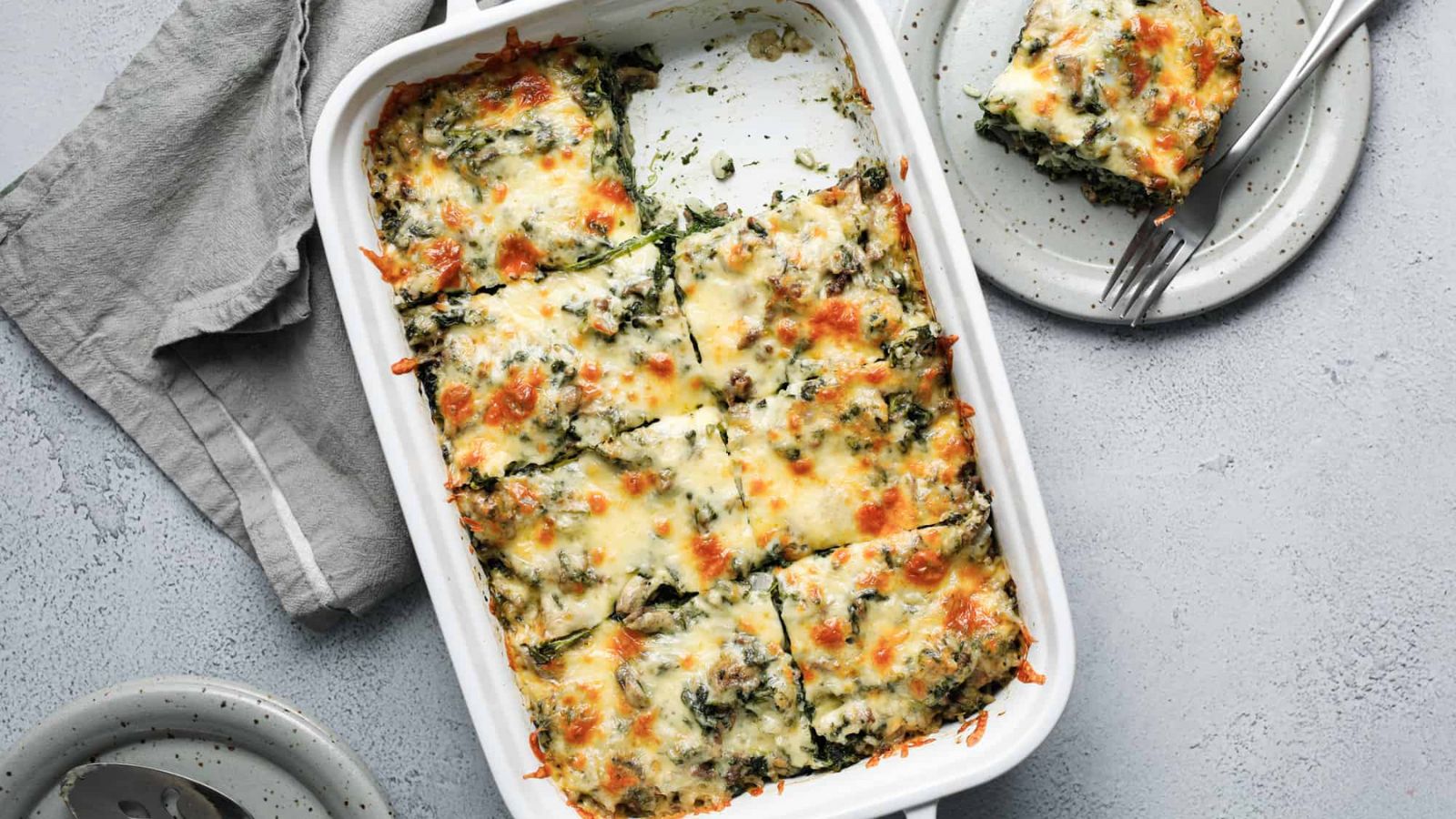 Spinach and beef casserole on a tray and on a plate.